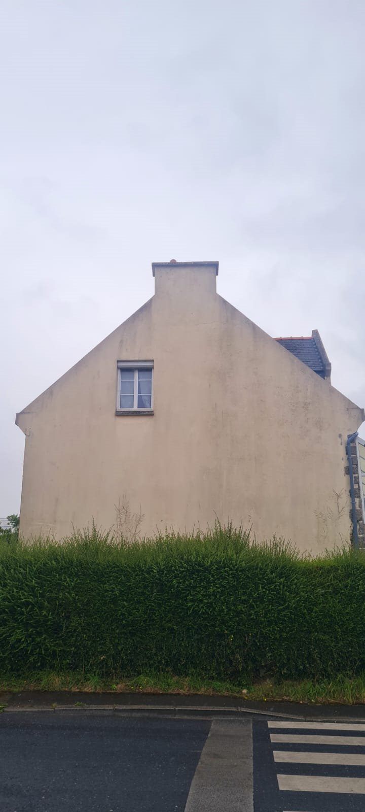 Façade et pignon de maison marqués par les mousses et les coulures, avant nettoyage