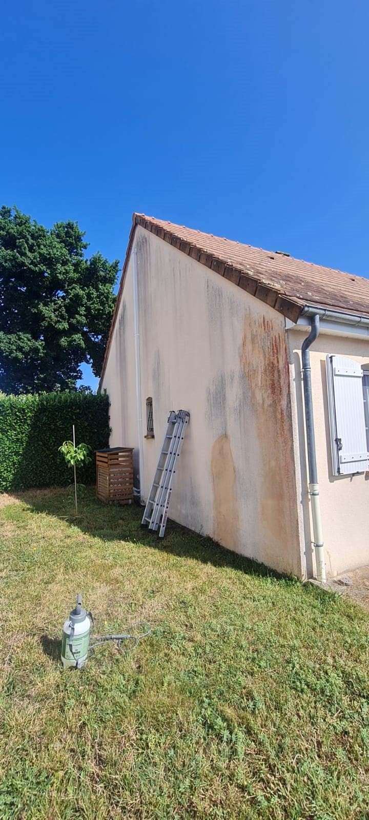 Mur pignon couvert de coulures grises et de traces sombres, avant nettoyage